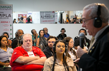 Presidente do TRT-MG fala com o microfone em mãos para público presente na palestra magna no Expominas