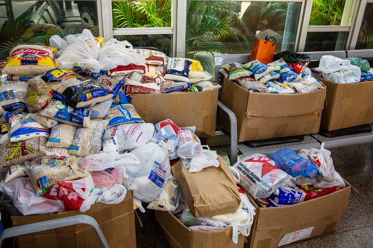 Foto mostra os alimentos arrecadados empilhados e espalhados