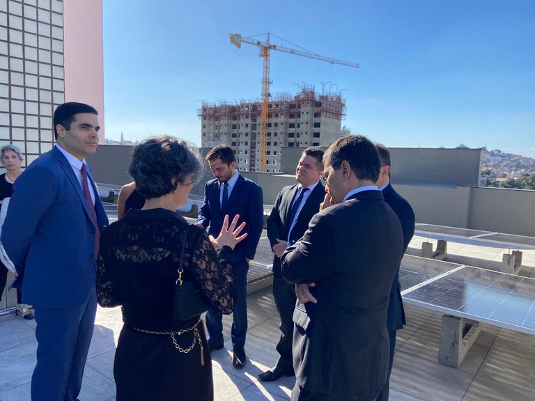 foto da diretora-geral Patrícia Reis em visita guiada com imprensa e membros do Poder Judiciário na cobertura perto de painéis solares