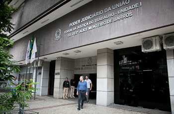 Foto da fachada da unidade 1 do Fórum de BH com transeuntes passando pelo local