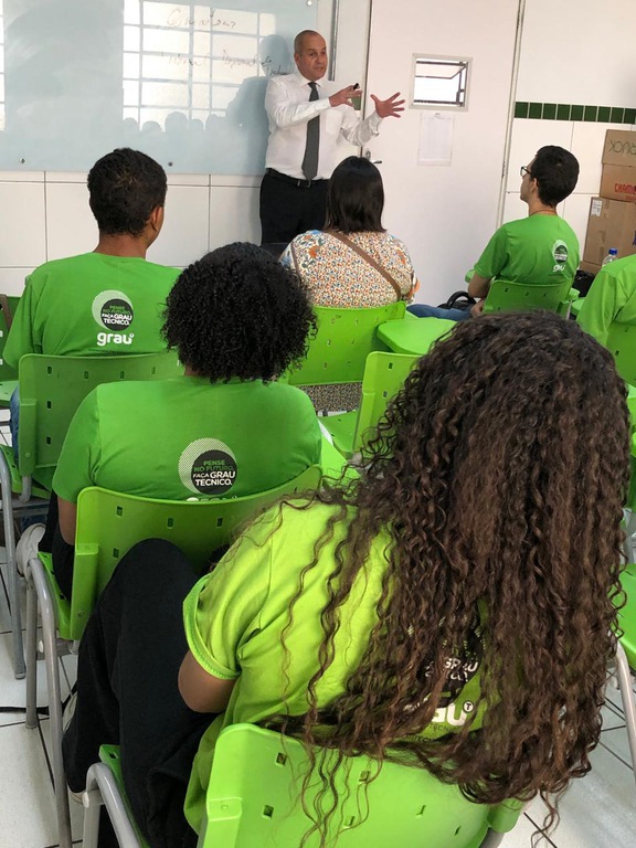 foto do desembargador Marcelo Pertence na frente de sala de aula falando aos alunos