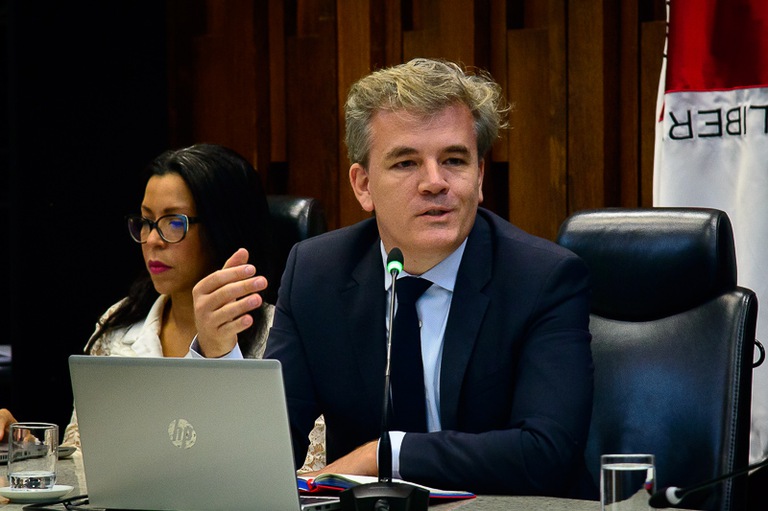 foto do psiquiatra Frederico Garcia de terno escuro palestrando