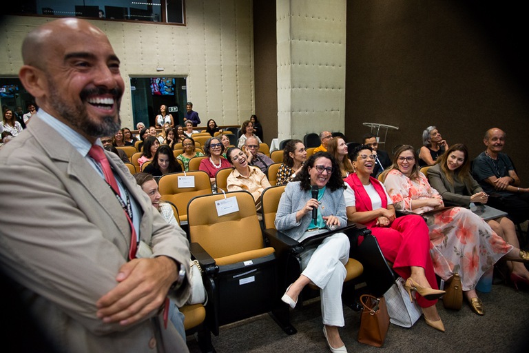 foto do chefe da seção de Teletrabalho do Tribunal, Henrique Carvalho, sorridente perto da plateia