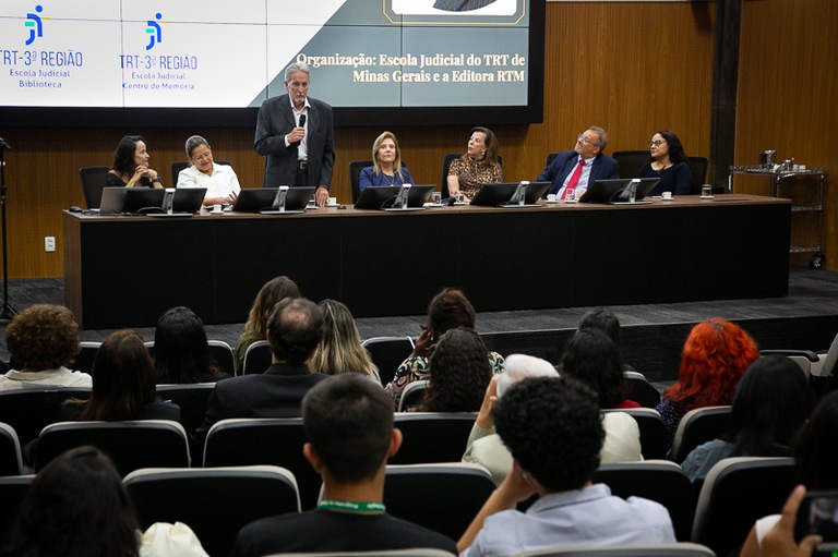 Auditório e mesa de honra do evento no segundo plano