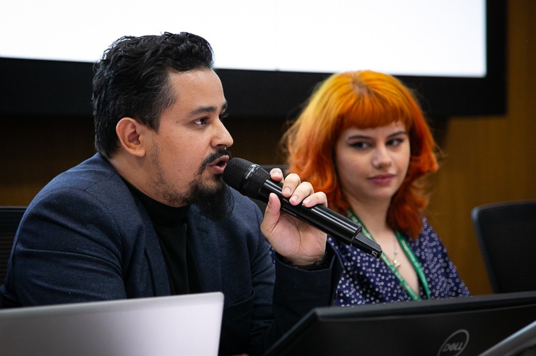 foto do palestrante e bibliotecário da Faculdade Dom Helder, Lucas Martins de Freitas Júnior, falando ao microfone 