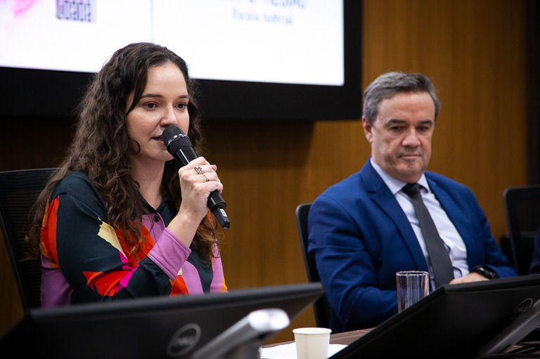 foto da Bruna Roriz, historiadora do Centro de Memória/Escola Judicial do TRT-MG, falando ao microfone