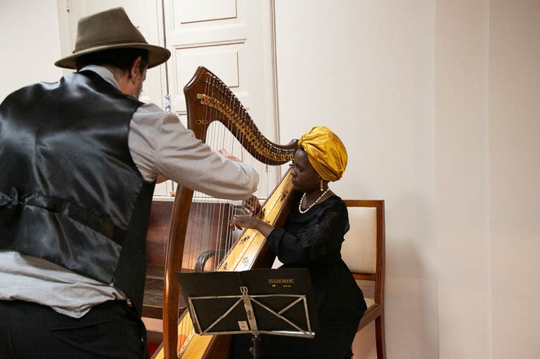 2025 1023 Homenagem Magistrados Aposentados-46.jpg foto de mulher negra de turbante amarelo tocando harpa