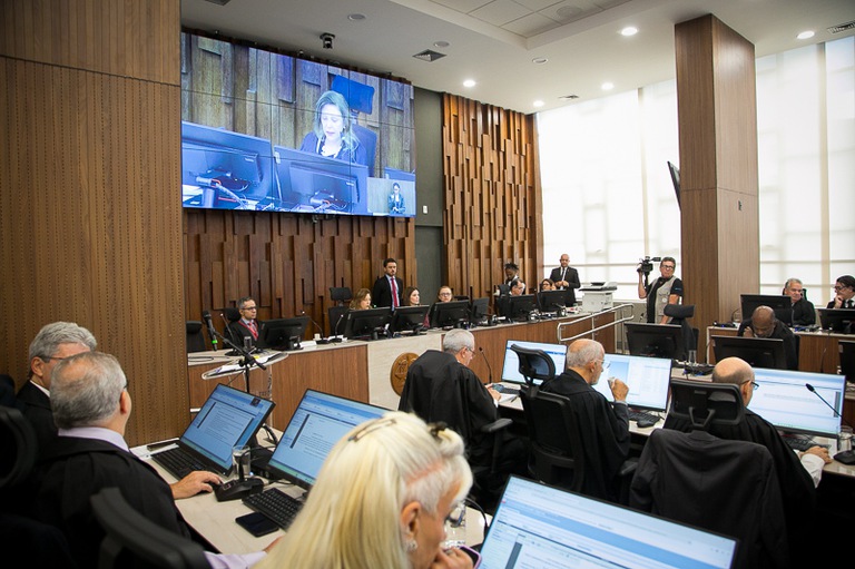 2025 1113 Pleno-06.jpg foto do plenário com telão ao fundo e desembargadores de toga preta sentados