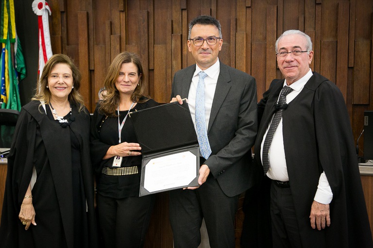 2025 1113 Pleno-12.jpg foto do juiz titular Vanderson Pereira de Oliveira e da diretora de secretaria Rosemary Akel Porfírio Oliveira recebendo o certificado.