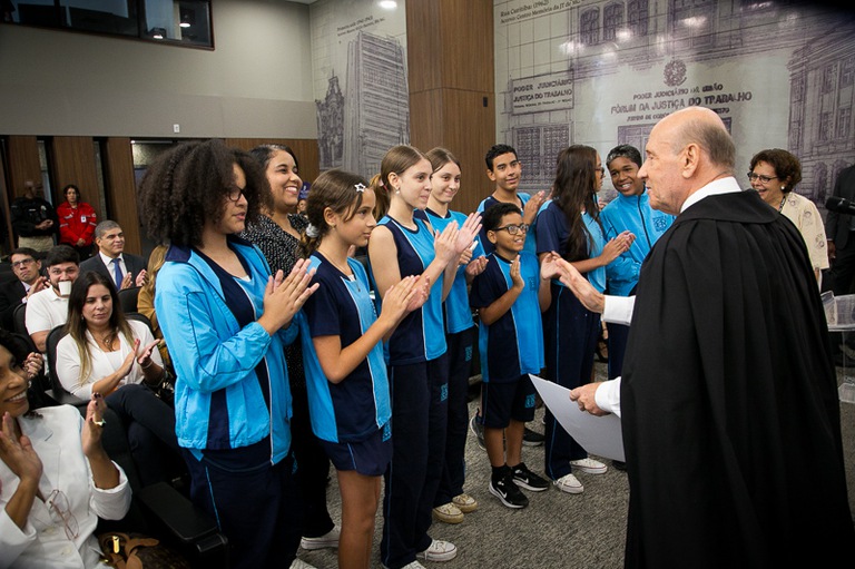 2026 0312 Pleno-20.jpg foto dos alunos da Escola Estadual Leon Renault em pé aplaudindo o desembargador Luiz Otávio Linhares Renault de frente