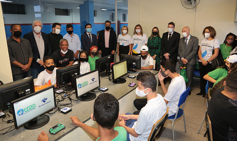 Foto de alunos da escola municipal Belo Horizonte usando os microcomputadores e as autoridades observando