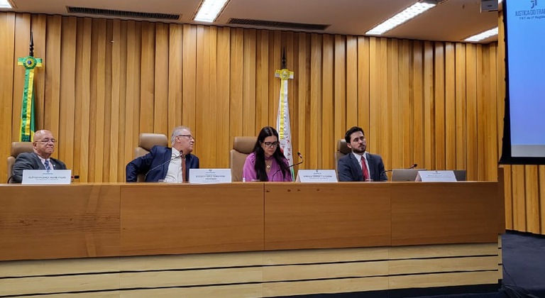 Juiz Renato Amado assentado à mesa no auditório do TST, durante apresentação ao COLEPRECOR