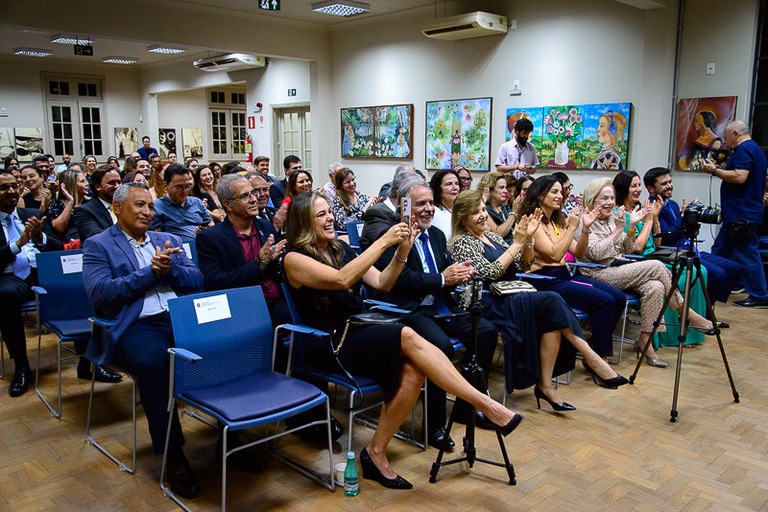 foto da plateia sorridente e aplaudindo