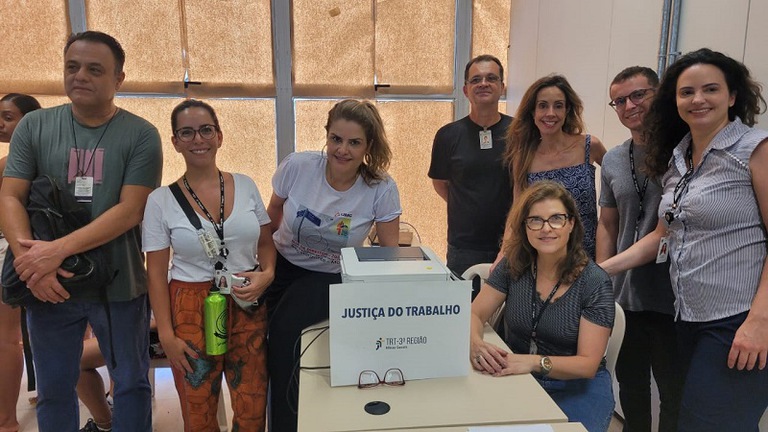Sete servidores do TRT-MG, em pose, sorrindo. Eles participaram do evento do TJMG
