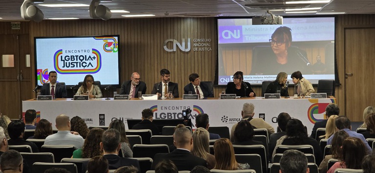 foto da mesa de honra do evento com autoridades e plateia assistindo