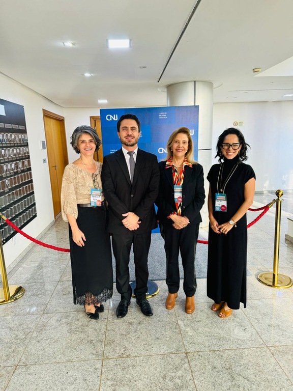 foto dos 4 participantes do TRT-MG na reunião preparatória, em pé e sorridentes. 