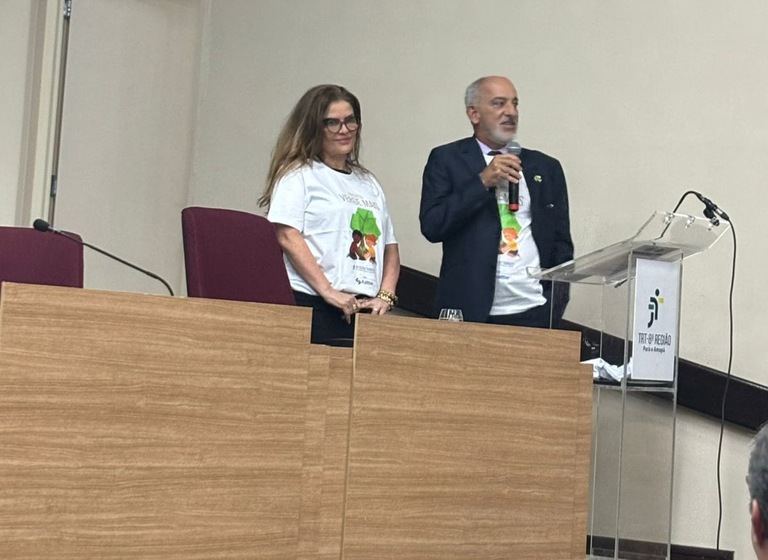 WhatsApp Image 2025-11-14 at 20.14.48.jpeg foto do corregedor, desembargador Manoel Barbosa da Silva, e da chefe do Núcleo de Gestão Sustentável e Inclusão do TRT-MG, Júnia Paula Fernandes de Oliveira, em pé palestrando