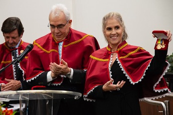 foto da desembargadora Rosemary Pires sorridente e com medalhas na mão e usando capa vermelha
