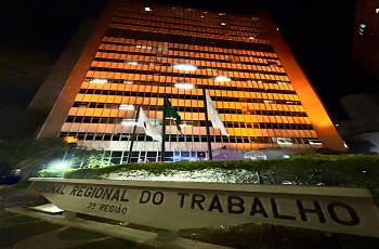 Prédio sede do TRT iluminado de alaranjado