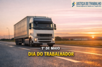 A imagem mostra uma estrada asfaltada sob a luz suave do pôr do sol. O céu está tingido de tons quentes, alaranjado, rosado e azul claro, com o sol baixo no horizonte, à direita. No centro da imagem, um caminhão grande e branco, com cabine moderna e faróis acesos, avança pela pista da esquerda em direção ao lado direito da imagem. O caminhão puxa uma carreta longa coberta por lona cinza-clara. Sobre o asfalto, na parte inferior da imagem, aparecem duas frases centralizadas: “1º DE MAIO”, escrita em letras brancas e maiúsculas, com leve sombra para dar profundidade. Logo abaixo, separada por um pequeno espaço, “DIA DO TRABALHADOR”, em letras amarelas, também maiúsculas e com sombra sutil. No canto superior direito da imagem, está o logo da Justiça do Trabalho. O conjunto transmite uma sensação de movimento, força e serenidade, simbolizando o trabalho e o esforço humano sob uma luz acolhedora de fim de tarde.