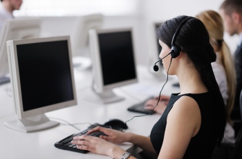 Foto de uma atendente de telemarketing trabalhando.
