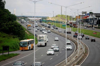 Foto de vários tipos de carro trafegando no trânsito urbano intenso.