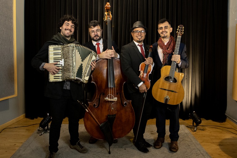 A imagem mostra o grupo musical Outro Gato posando junto de seus respectivos instrumentos.