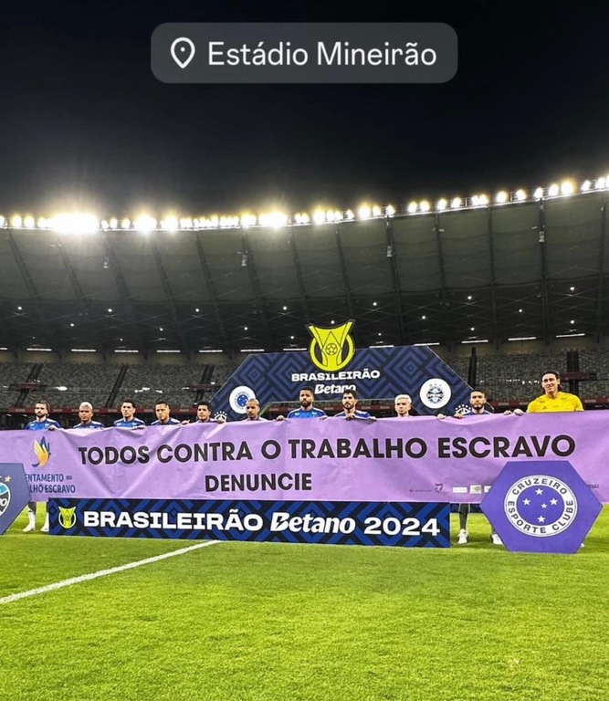 Jogadores e autoridades seguram faixa com a seguinte mensagem “Todos contra o trabalho escravo. Denuncie"