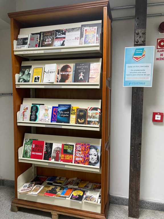 Estante de livros com diversos livros em todas as prateleiras na Escola Judicial.